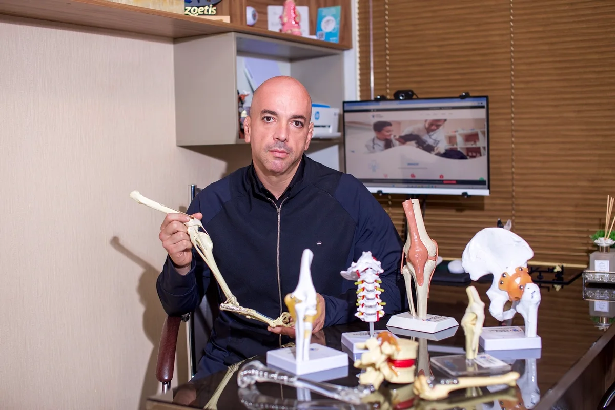 Dr. Pedro Campos com modelos anatômicos em seu consultório