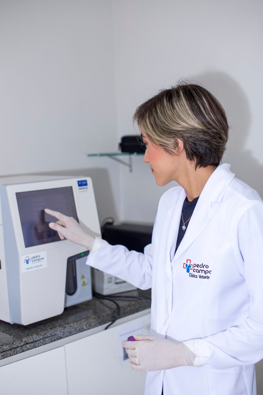 Profissional operando o analisador laboratorial do hospital